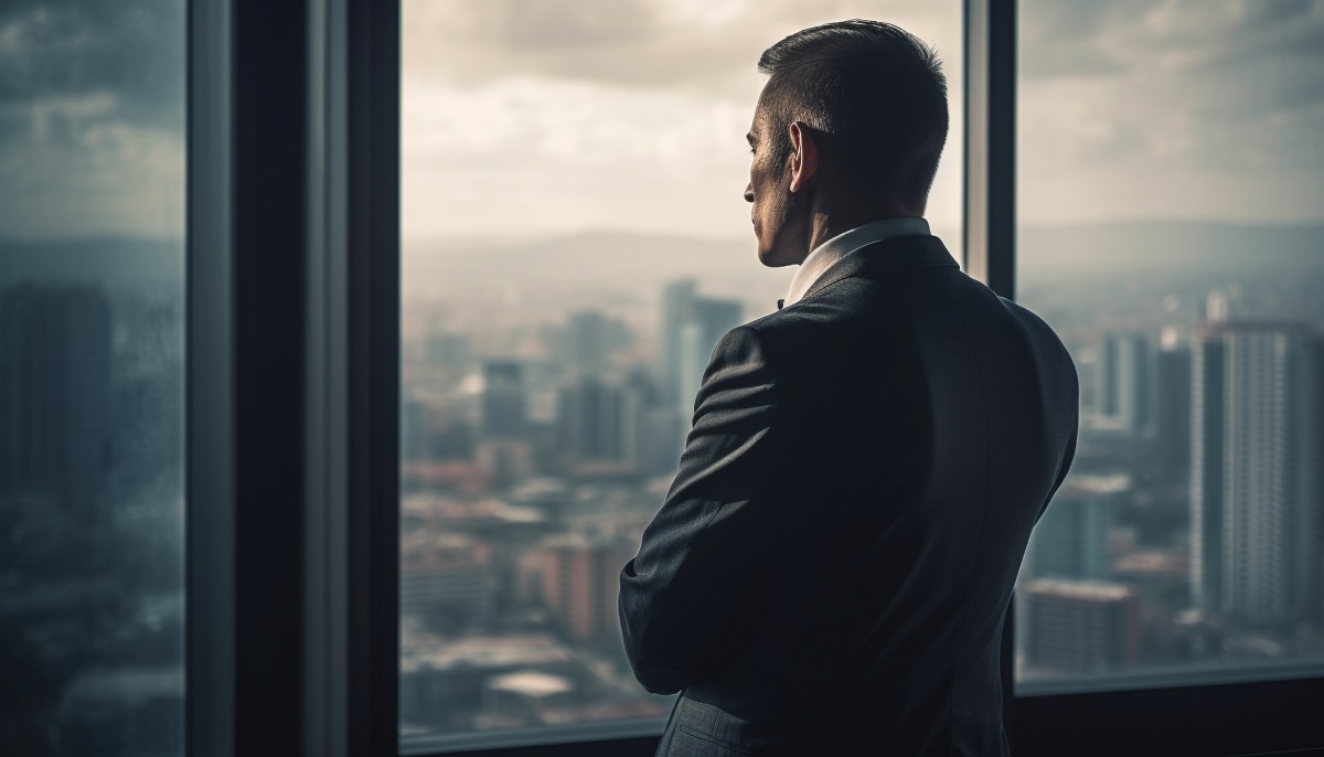 Empresario viendo la ciudad a través de la ventana