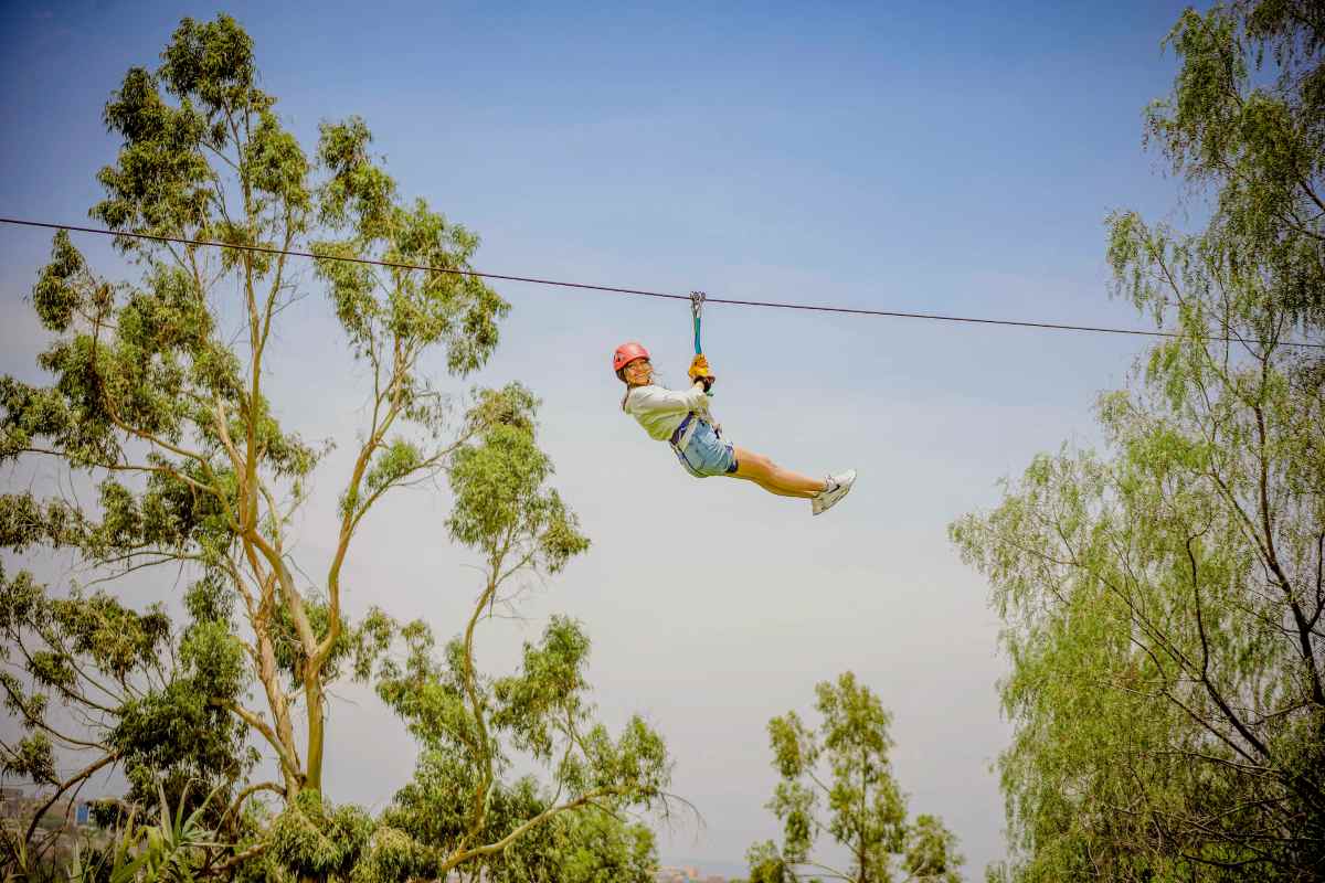 Persona colgando de un hilo sobre un bosque