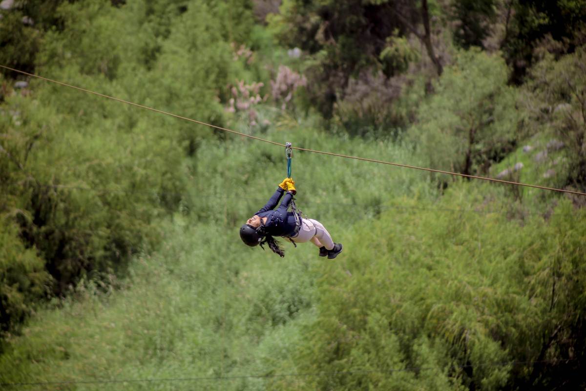 Persona colgando de un hilo sobre un bosque