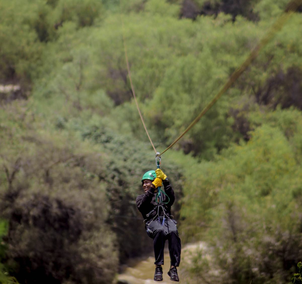 Persona colgando de un hilo sobre un bosque