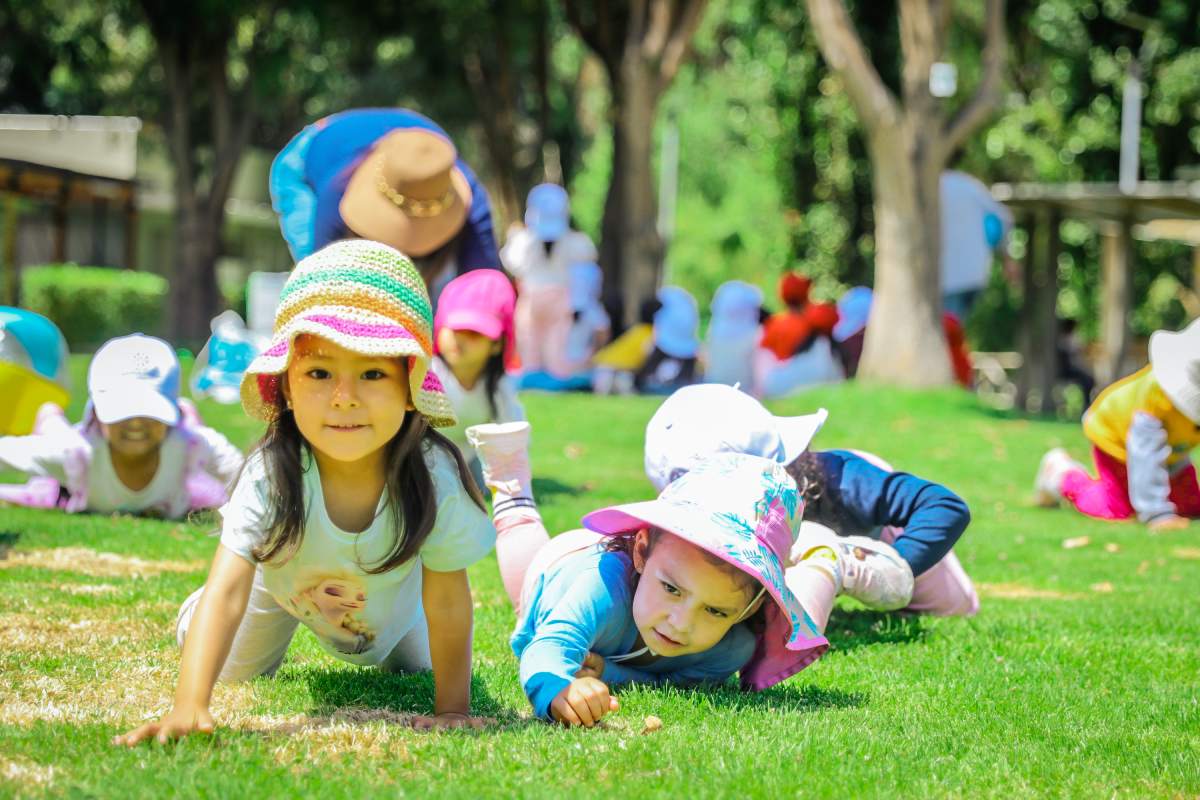 Niños gateando sobre el pasto