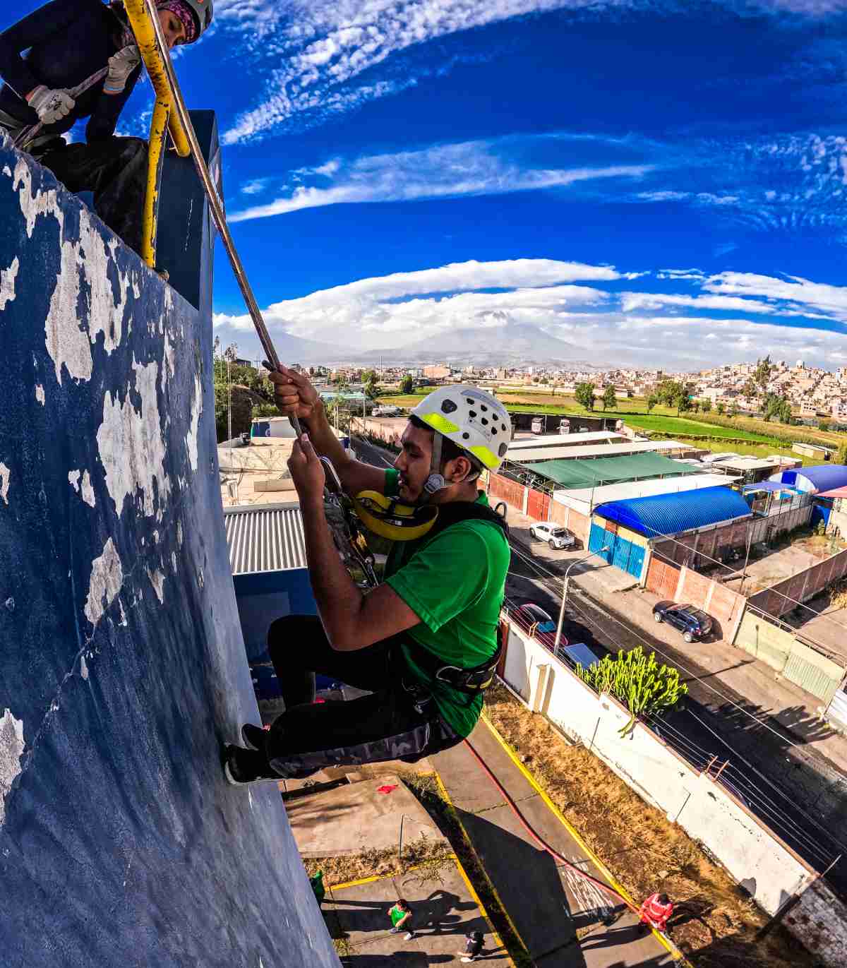 Persona colgando de un hilo sobre un edificio