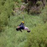 Persona colgando de una cuerda sobre el bosque